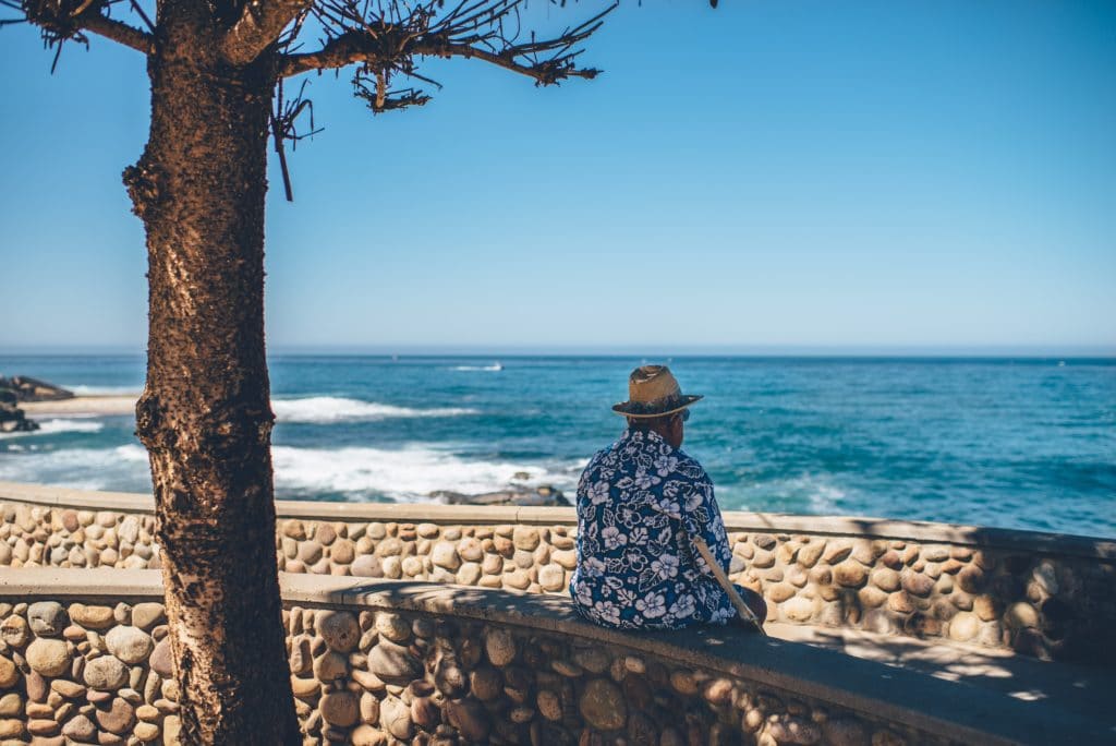 Elderly man sitting on the coast